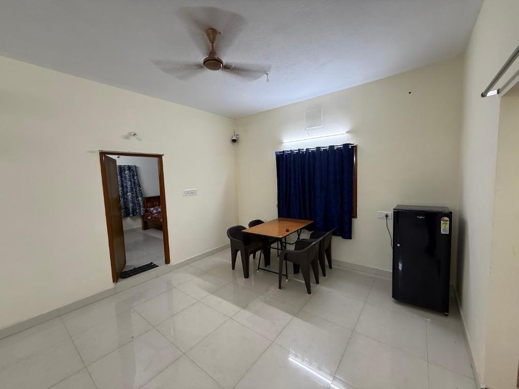 a dining room with a table and chairs and a ceiling fan at APK living in Chennai