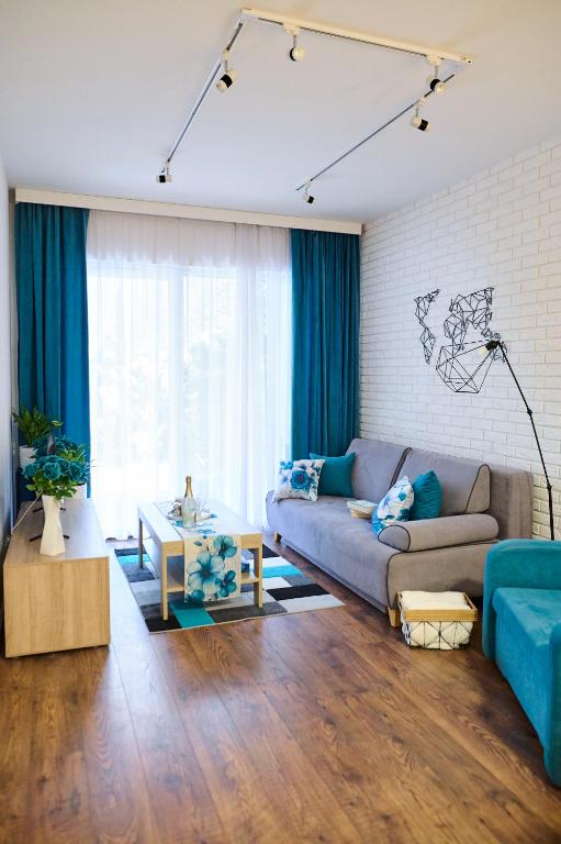 a living room with a couch and a table at Apartament BLASK Jeziora in Augustów