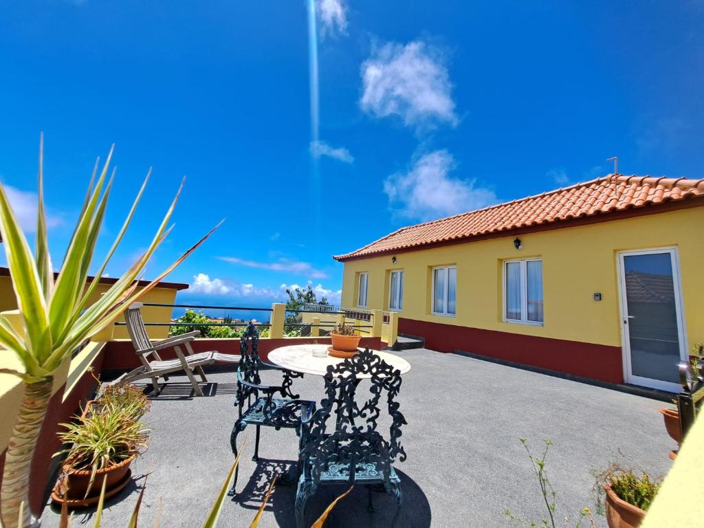 a patio with chairs and a table in front of a house at Calheta Countryside in Calheta