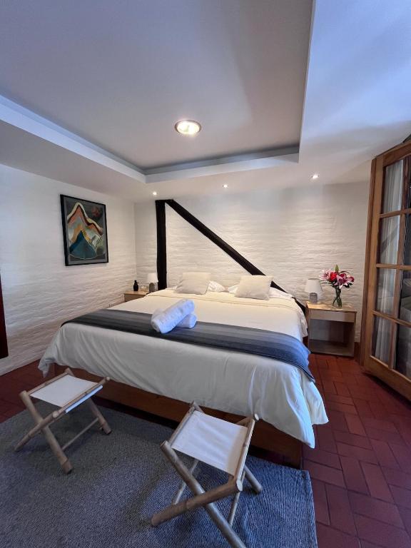 a bedroom with a large bed and two chairs at Modern Apartment with Private Balcony in Quito