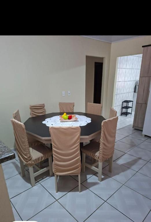 a dining room table with chairs and a bowl of fruit on it at Sitio4meninos in Pinheiral