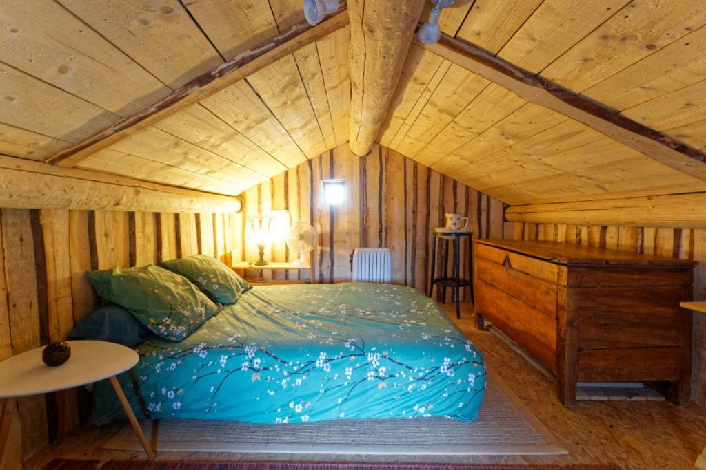 a bedroom with a bed and a wooden ceiling at Maisonnette cocooning, ancien four à pain in Saint-Éloy-la-Glacière