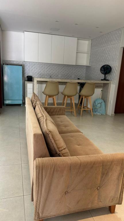 a couch in a living room with a kitchen at Bela Gold Alto Caparaó in Caparaó Velho