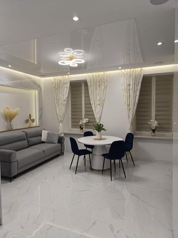 a living room with a couch and a table and chairs at Blu Apartments -Rynek in Nowa Ruda
