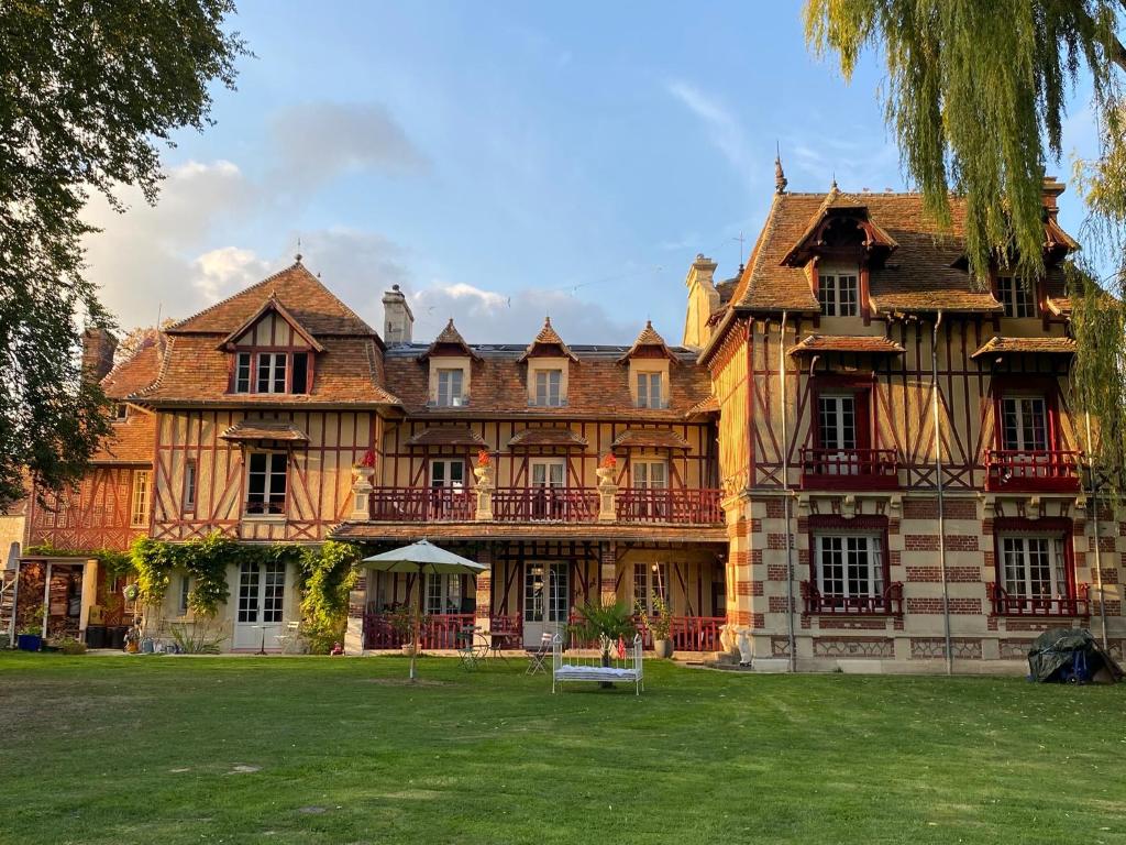 a large house with a yard in front of it at Manoir des Étangs in Croissanville