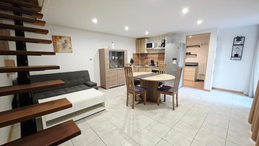 a kitchen and living room with a couch and a table at Le Grand Minck in Grand-Fort-Philippe