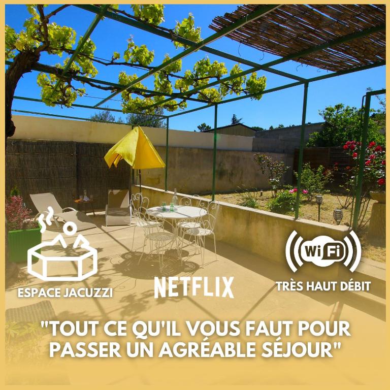 a patio with a table and a yellow umbrella at Sous La Treille in Saze