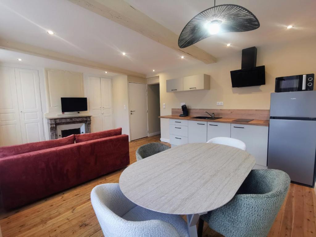 a living room with a table and a red couch at Premium Appartement Hesdin in Hesdin