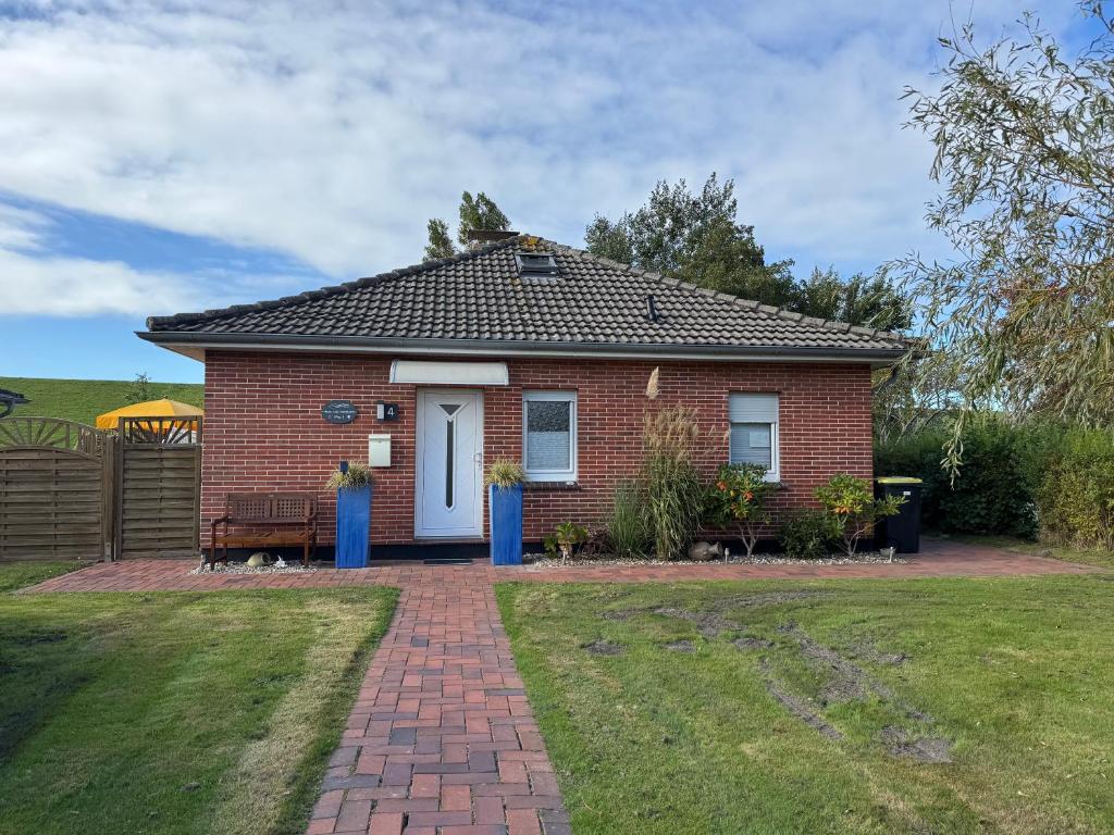 a small red brick house with a brick driveway at Haus Juist-Norddeich in Norden