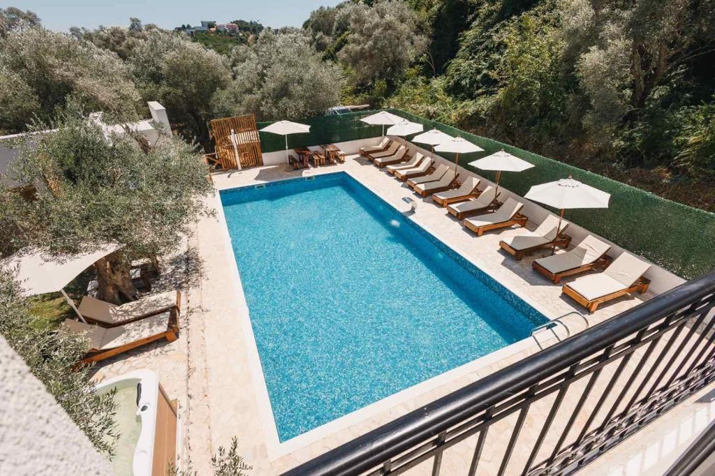 an overhead view of a swimming pool with chaise lounge chairs and a pool at Eman Resort in Ulcinj