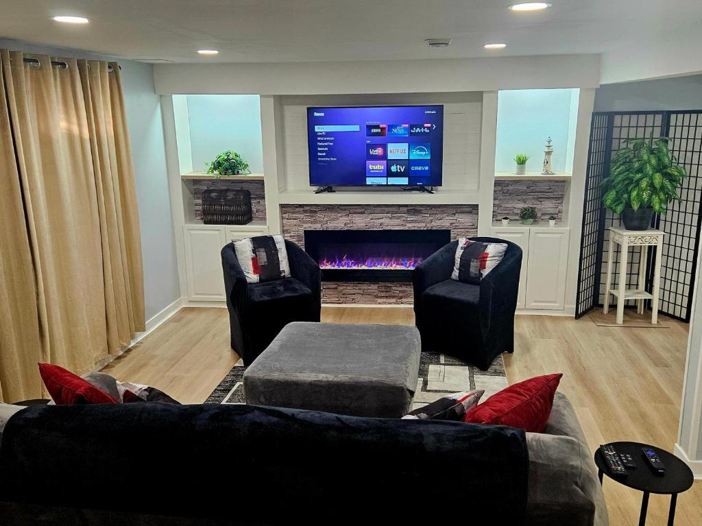 a living room with two couches and a tv at Queen City Comfort in Regina