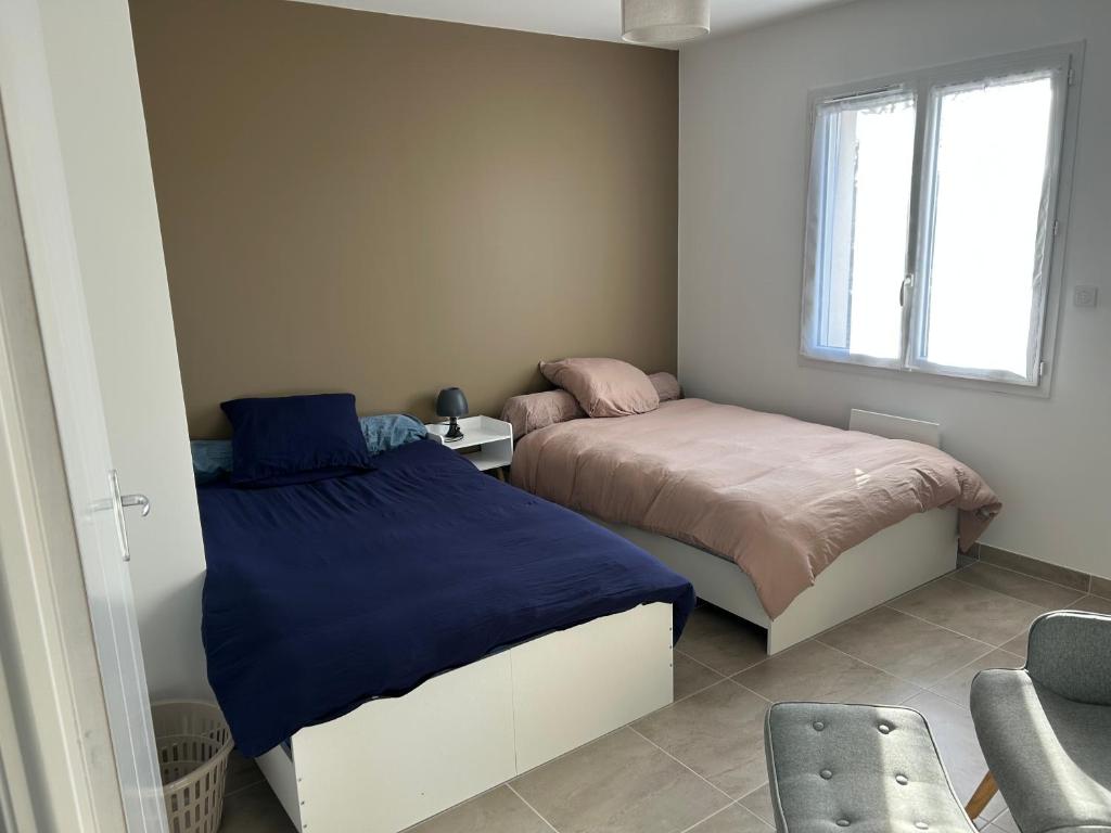 a bedroom with two beds and a window at Petite maison calme in Dun-sur-Auron