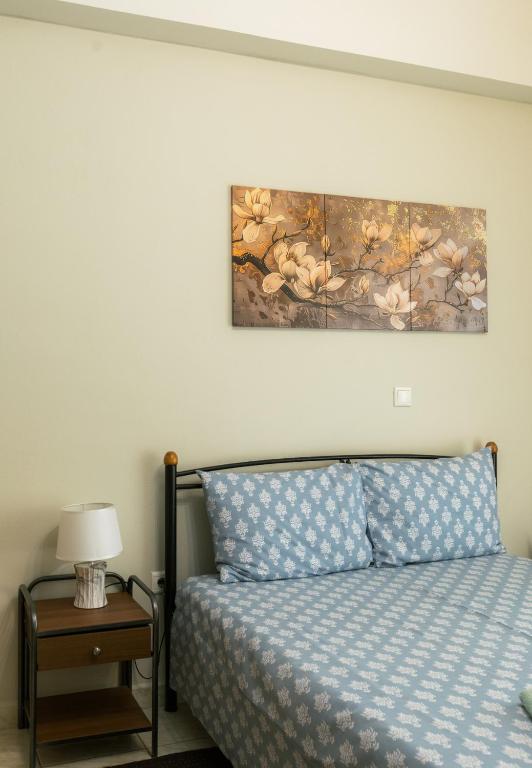 a bedroom with a bed and a painting on the wall at Central Cozy Apartment 2 in Sparta