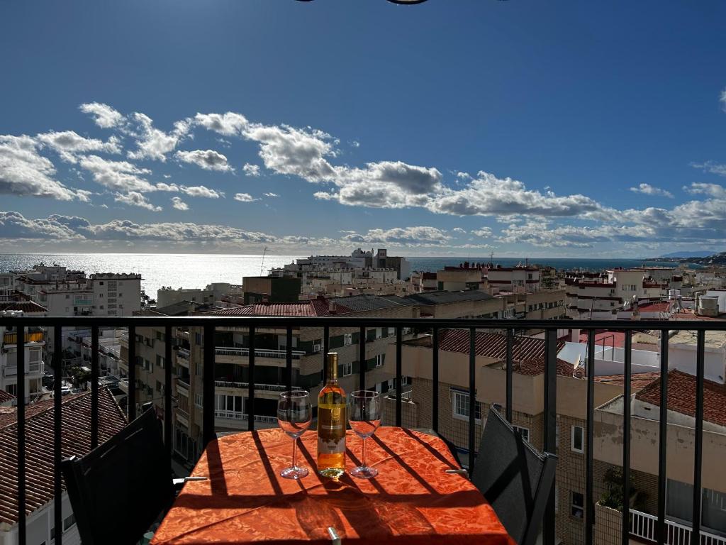 a table with a bottle of wine on a balcony at TuttiFruttiaApt in Nerja