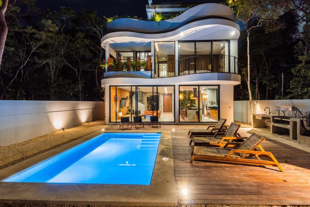 a house with a swimming pool in front of it at Luxury 4BR Eco Villa 10ppl Outdoor Pizza Oven - Private Pool & Jacuzzi in Tulum