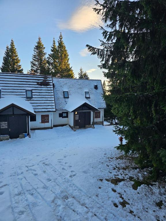 a barn with snow on the ground in front of it at Cosy Rogla appartment 108 in Zreče