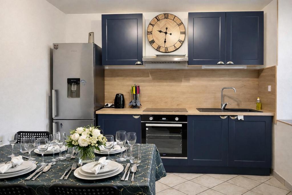 a kitchen with a table and a clock on the wall at LE GITE DES 2 FRERES in Arc-en-Barrois