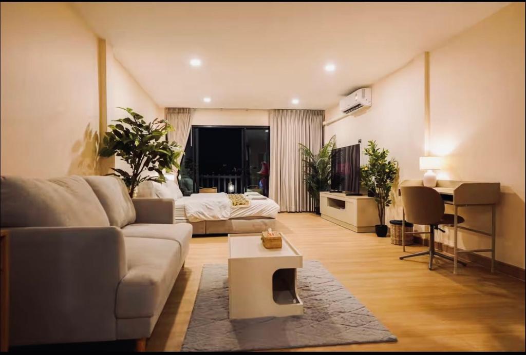 a living room with a couch and a bed at Ningle Place Hotel Pathumthani in Ban Pak Khlong Si