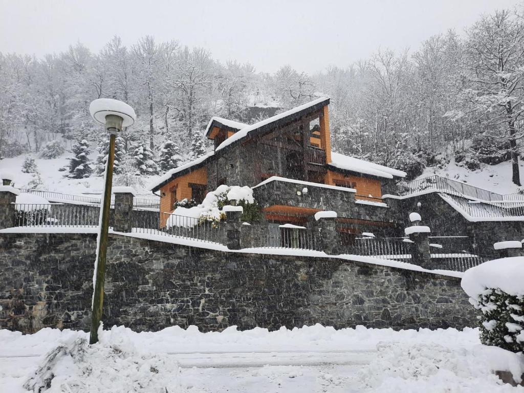 a snow covered building with a light pole in front of it at Les Bosquitos Chalet in Ax-les-Thermes
