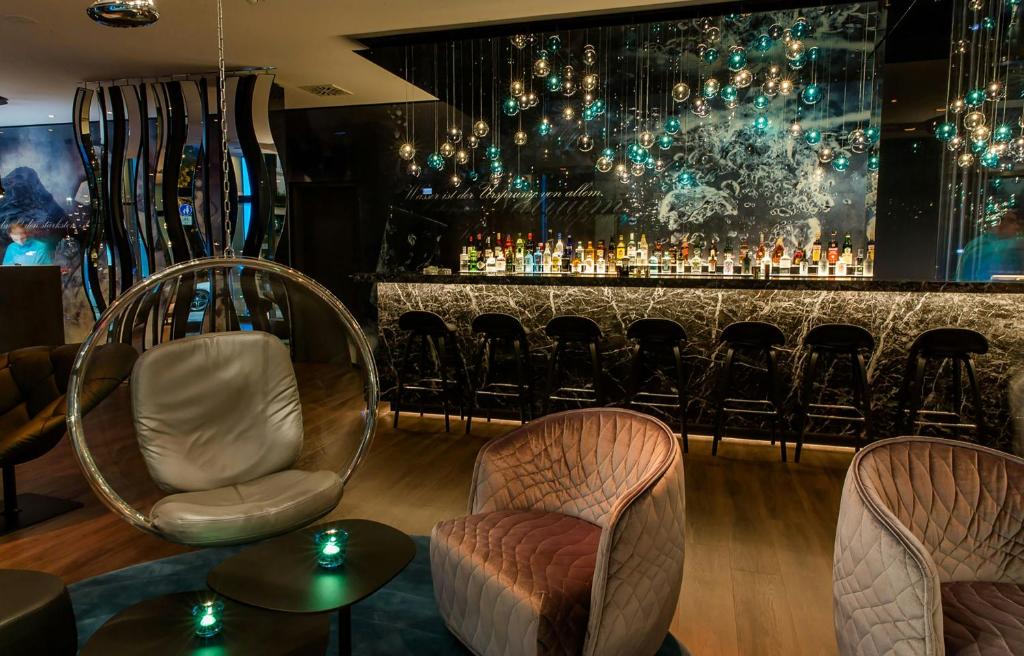a bar with chairs and a counter with drinks at Motel One Stuttgart-Bad Cannstatt in Stuttgart