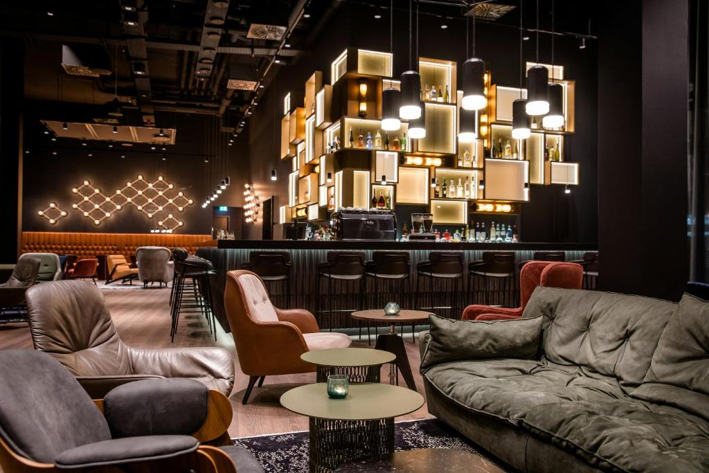 a lobby with couches and chairs and a bar at Motel One Stuttgart-Feuerbach in Stuttgart