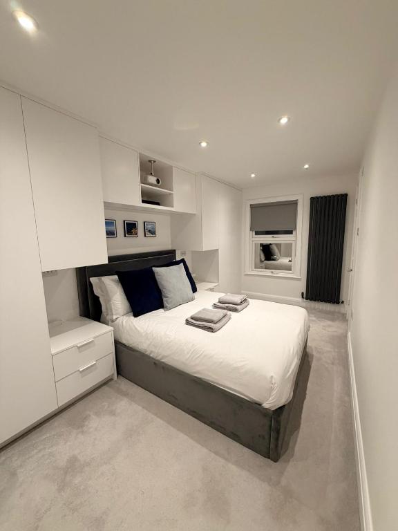 a white bedroom with a large bed in it at Adrian Cottage in Abbots Langley