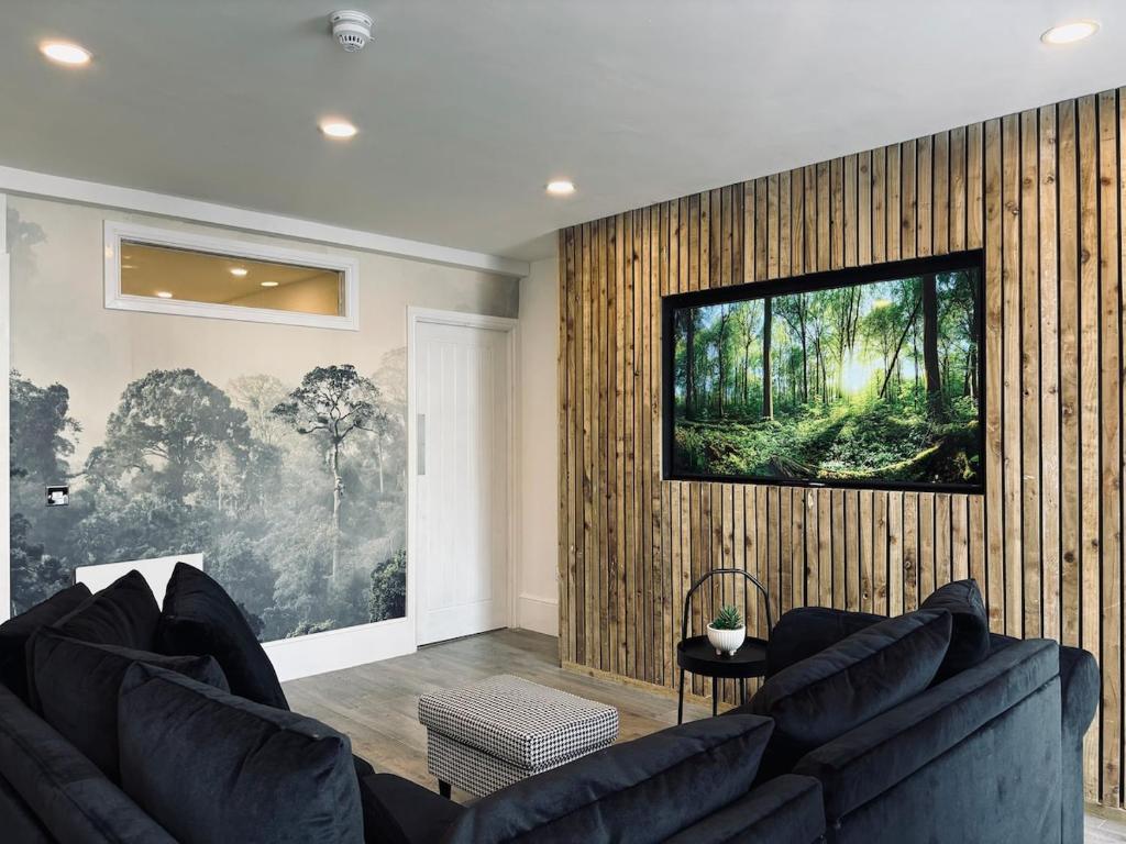 a living room with a couch and a television on a wall at Williamson Suites - Apartment 1 in Liverpool