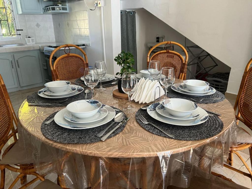 a dining room table with plates and wine glasses at TecTec 2 Appartment 1 in Pereybere