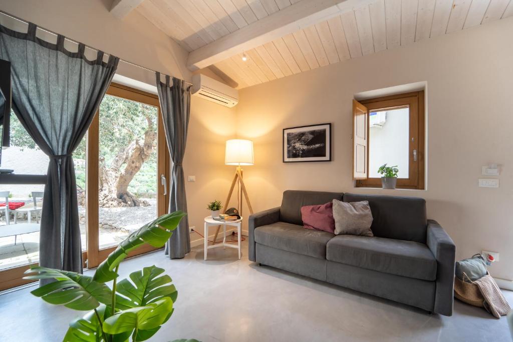 a living room with a couch and a window at Le Vie del Borgo | 3 dimore indipendenti a Civita in Civita