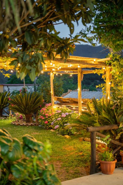 a wooden gazebo with lights in a garden at Agriturismo da Regina in Tramonti