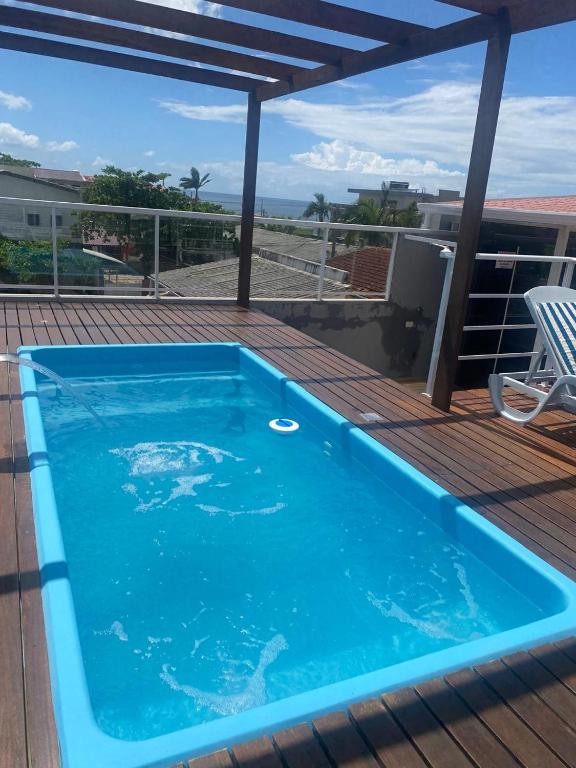 a blue swimming pool on top of a deck at Casa surf in Guaratuba