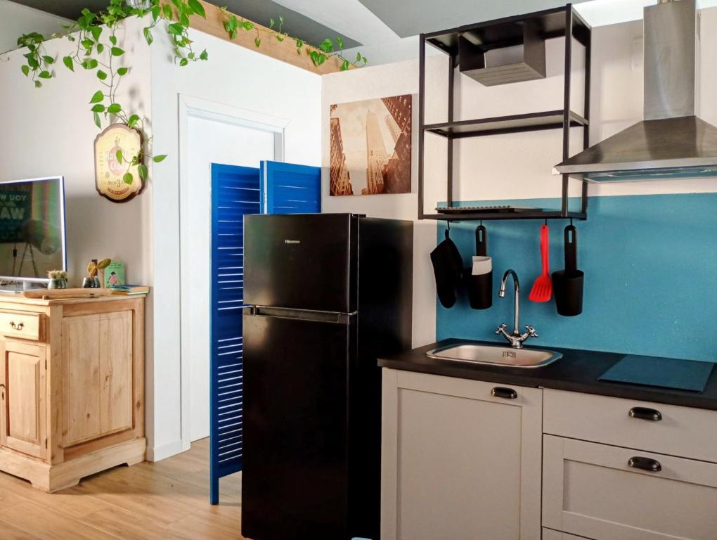 a kitchen with a black refrigerator and a sink at Jazz House in Solanas
