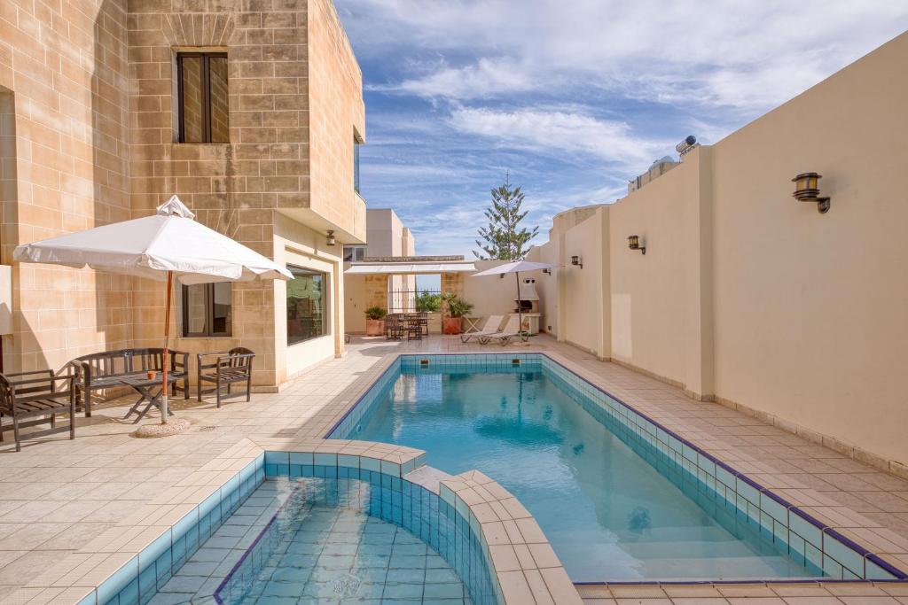 a swimming pool in the middle of a house at Luxurious Villa with pool in Il-Mielaħ