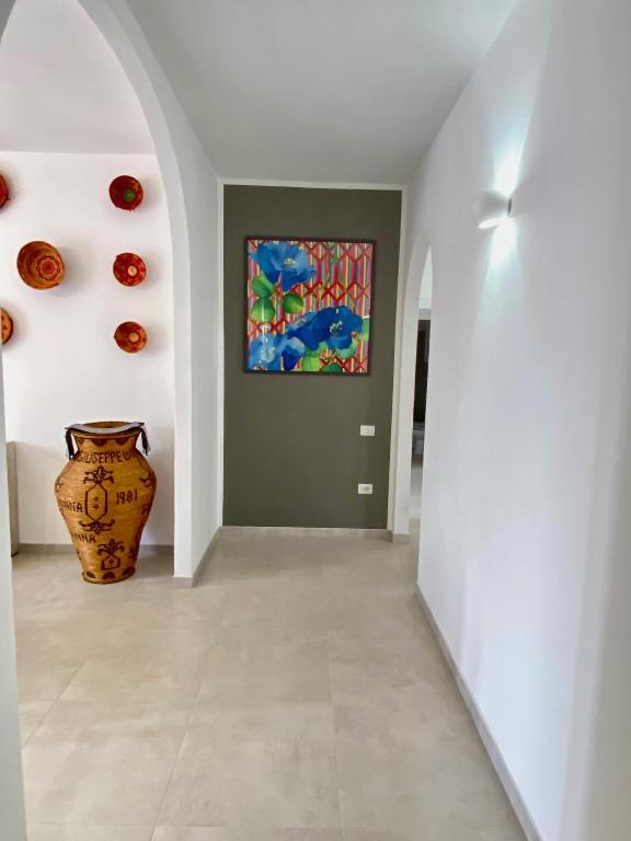 a hallway with a vase and a painting on the wall at Rooms Domu Ajo in Monserrato