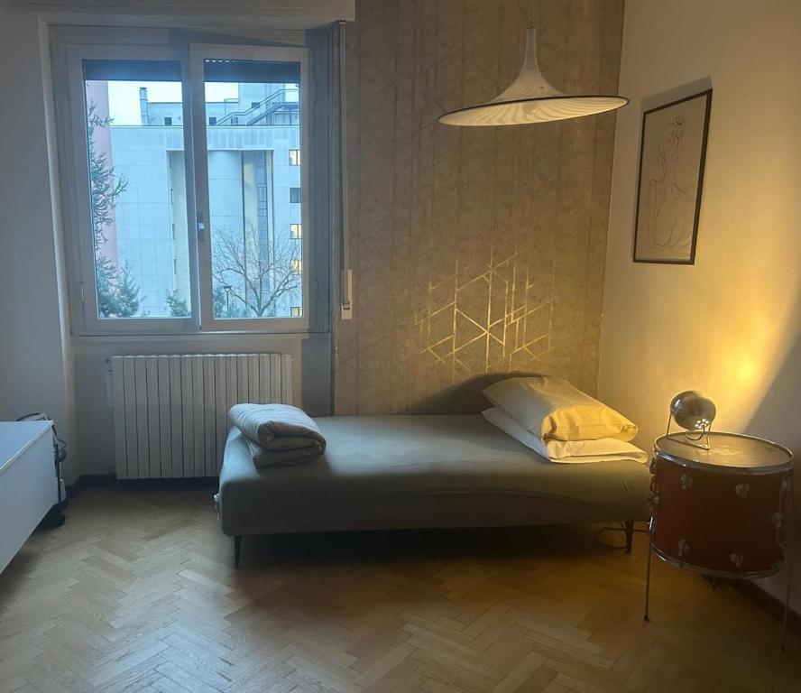 a small bed in a room with a window at Pit-Stop 2 in Monza