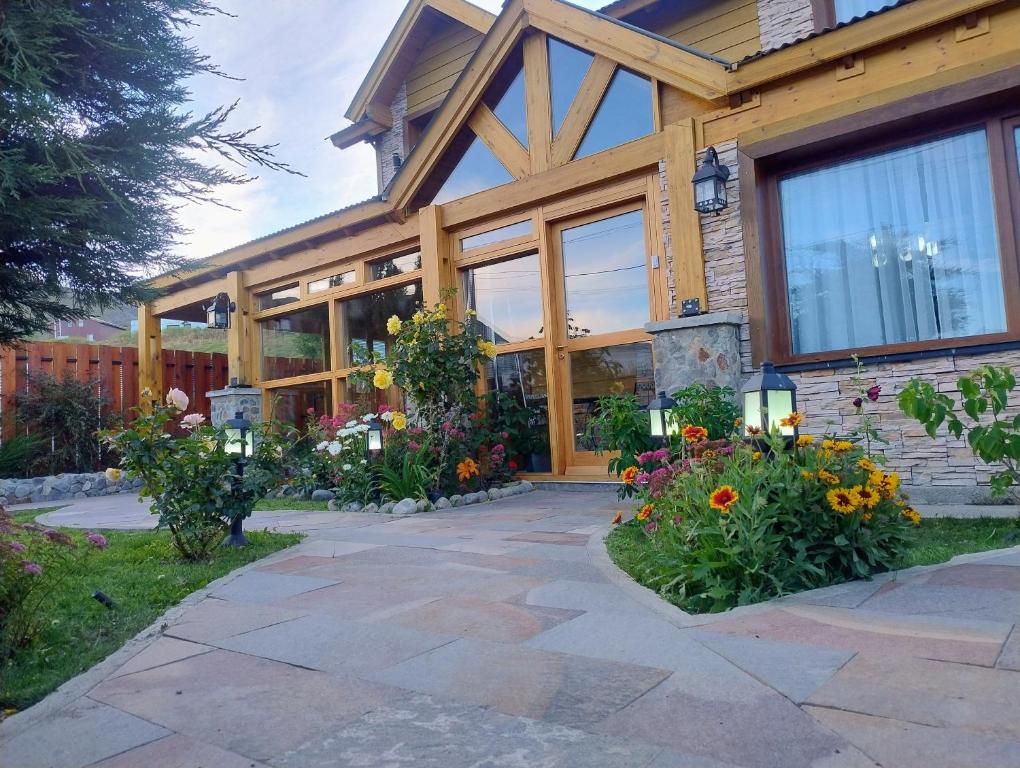 a house with flowers in front of it at Apart Ruta 40 in El Chalten