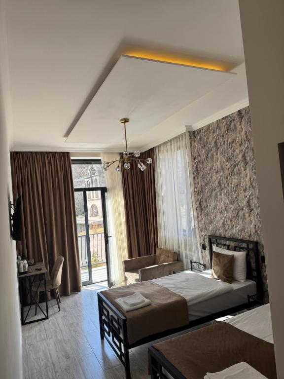 una stanza d'albergo con un letto, una scrivania e una stanza di Mony Hotel a Goris