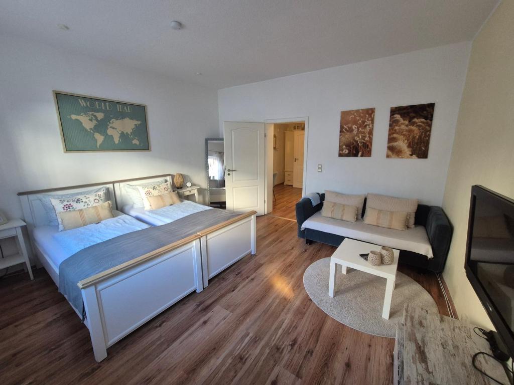 a bedroom with a large bed and a couch at Gästehaus Kampik in Witten
