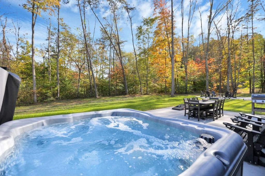 a hot tub on a patio with a table and chairs at Pine Grove Barndominium in Sugar Grove