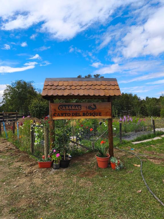 a sign for a garden with potted plants and flowers at Canto del Bosque in Castro