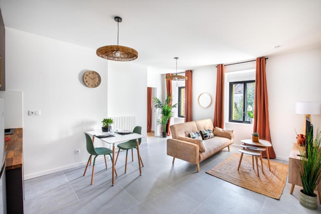 a living room with a couch and a table at Romantic getaway with jacuzzi, Garden view in Mulhouse