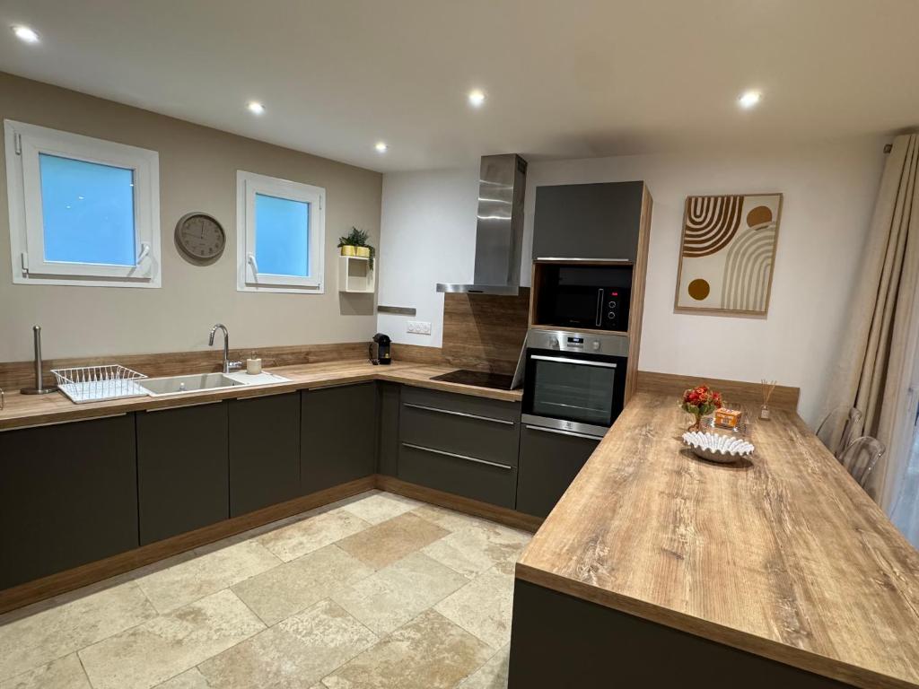 a large kitchen with a wooden counter top at SUPERBE T2 moderne - ENTREE DE VILLE - PARKING PRIVE in Ajaccio