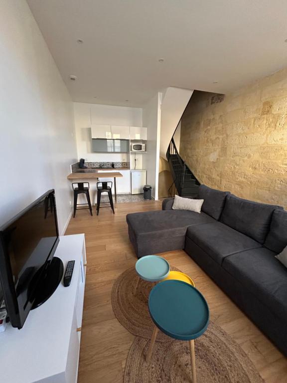 a living room with a couch and a table at Maison de ville in Libourne