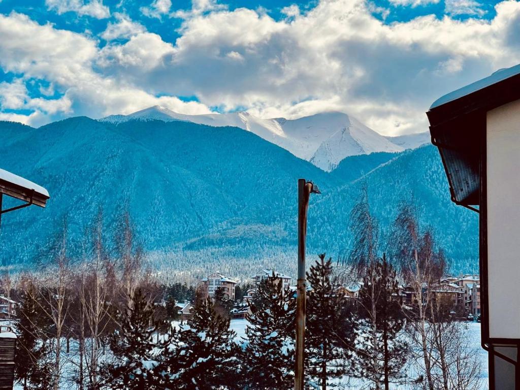 a view of a snowy mountain range with a city at Pirin Dream View Apartments in Razlog