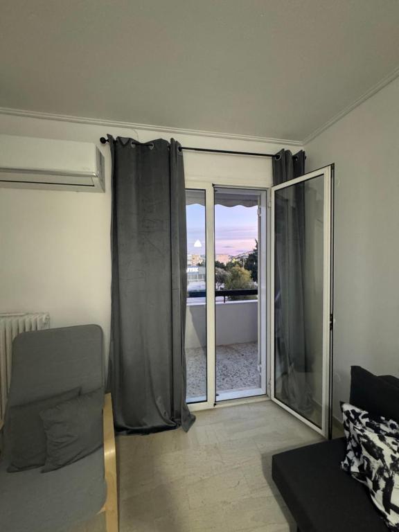a living room with a sliding glass door to a balcony at Dimitras Apartment with 3 bedrooms Elefsis in Eleusis