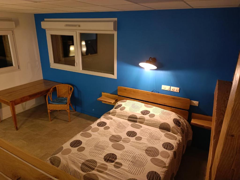 a bedroom with a bed and a blue wall at Appartement original tout confort in Condamine