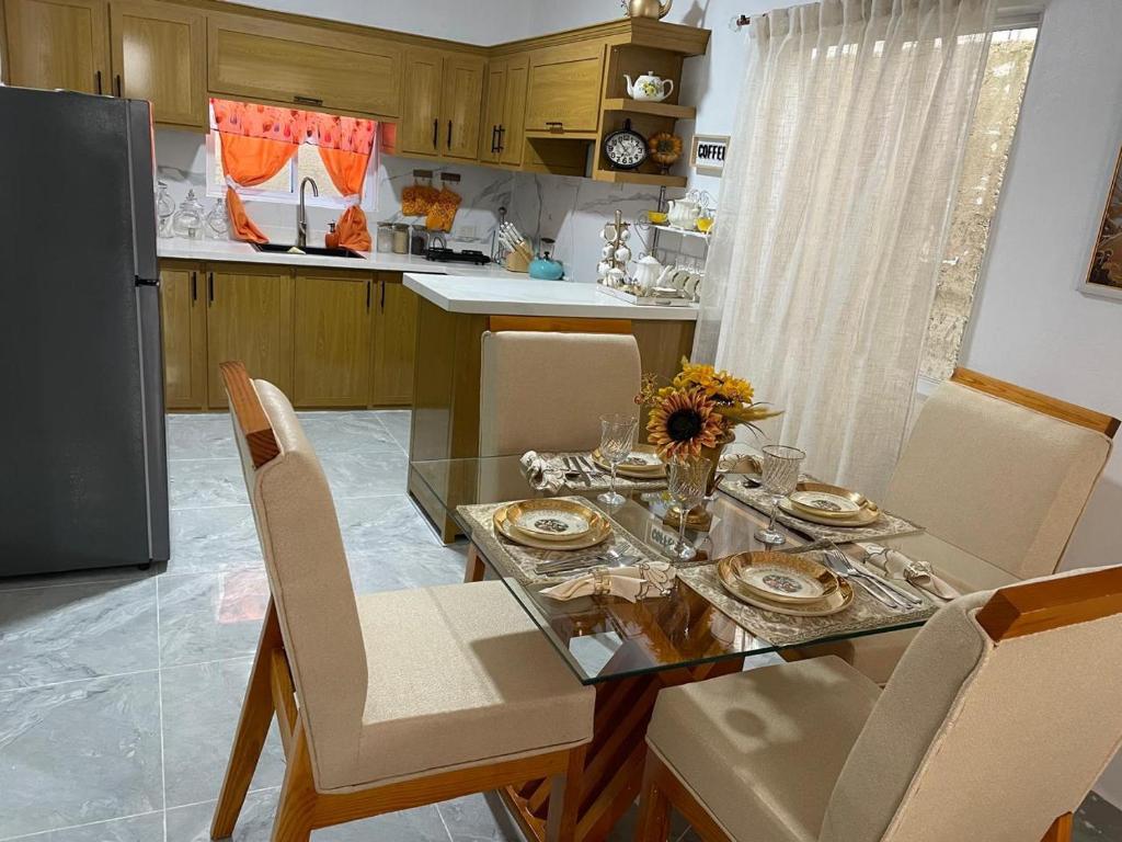 a kitchen with a dining table with chairs and a refrigerator at ajmicasita in Constanza