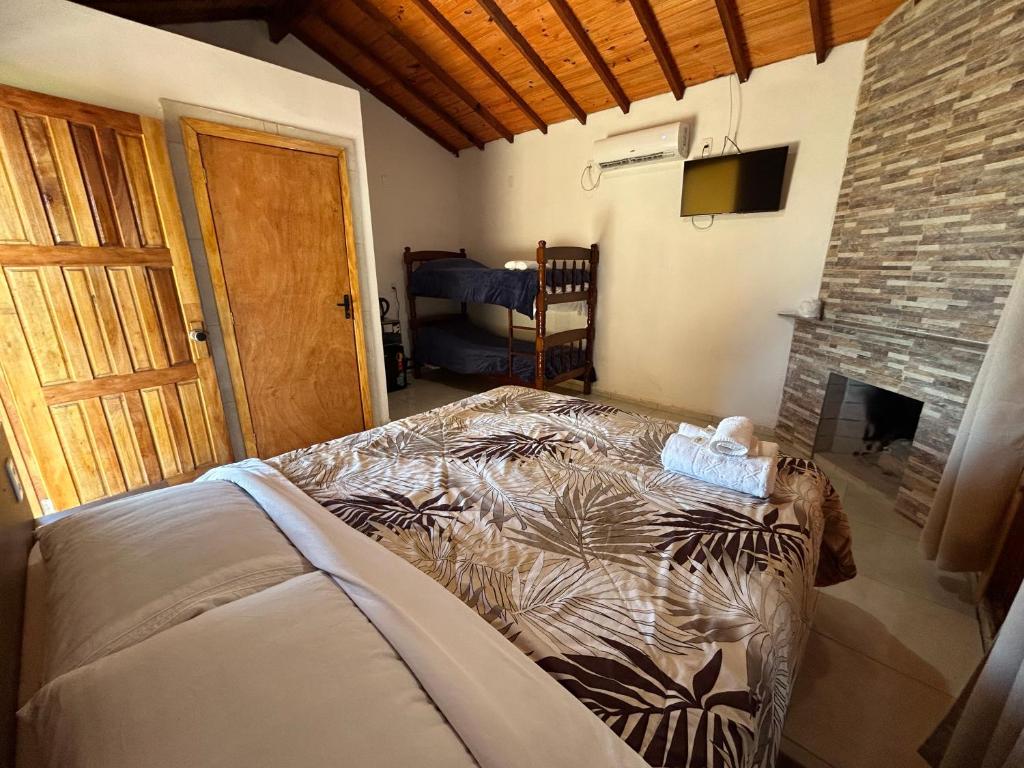 a bedroom with a bed in a room with a fireplace at Mini Fazenda Park in Santana do Livramento