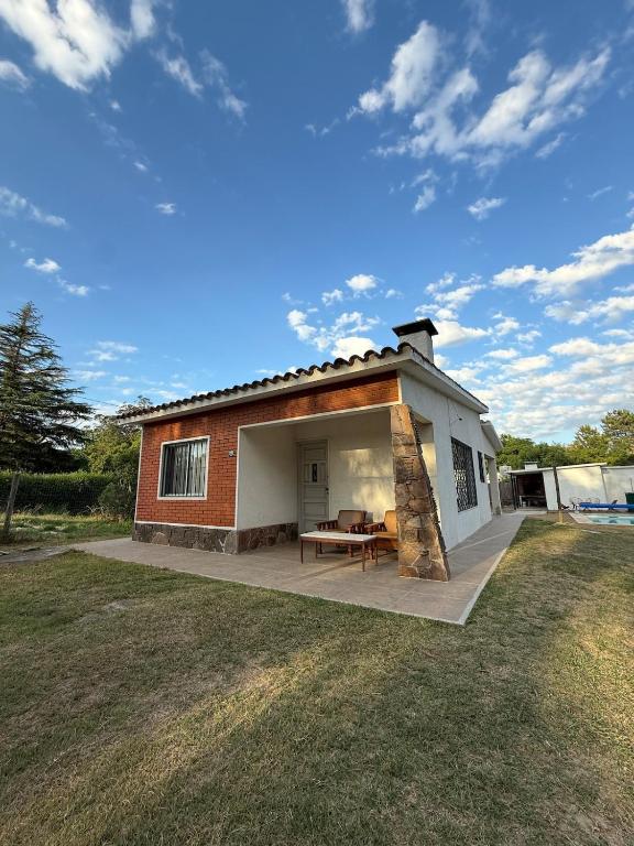 a small house with a patio and a table at House in La Tuna in Balneario Argentino