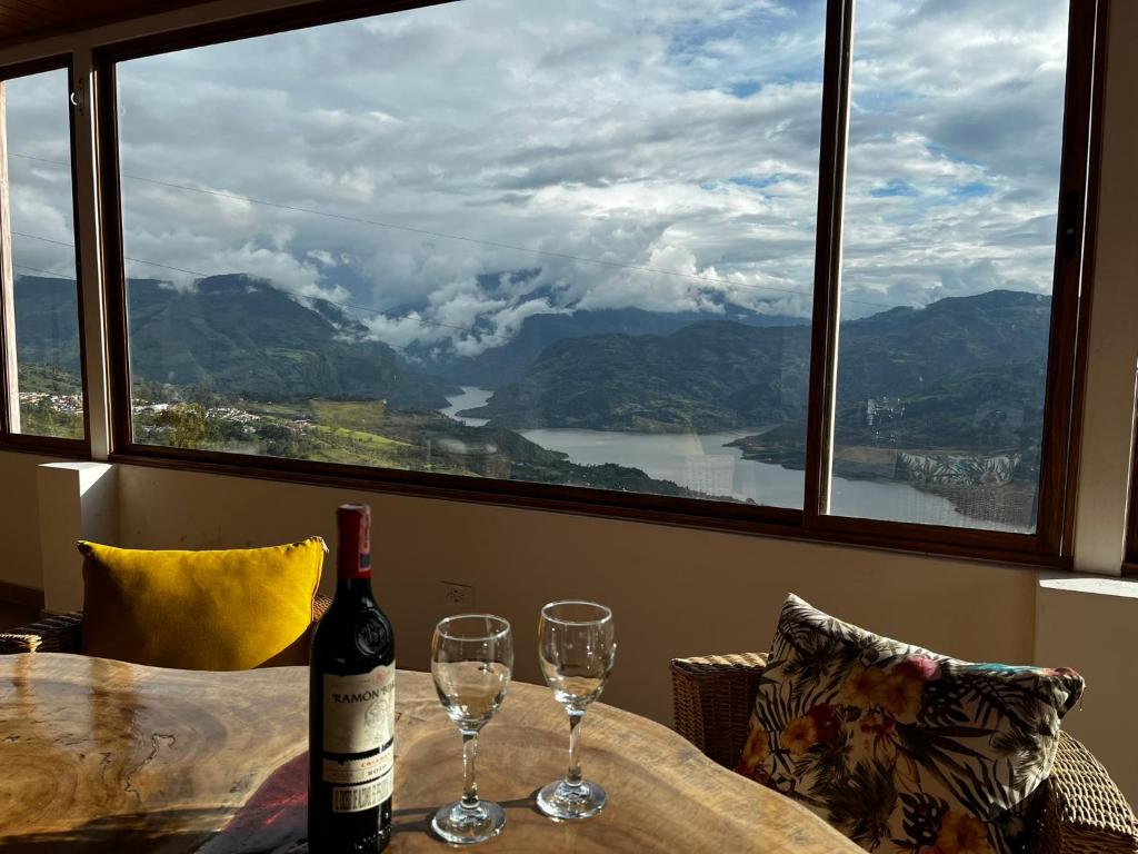 a bottle of wine sitting on a table with two glasses at Villa Celeste in Macanal